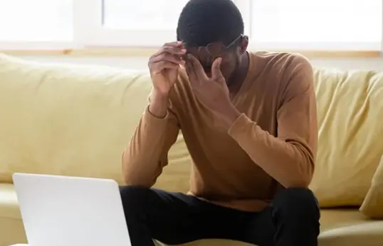 Person On Sofa Working From Home Suffering Stress Blog Page