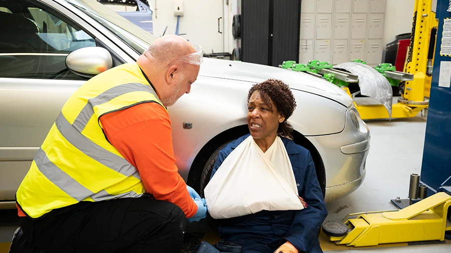 First aider helping casualty in the workplace